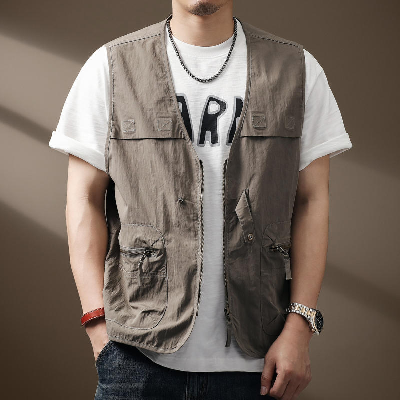 Medvilninė liemenė lauko žvejybai, siauras kirpimas, V kaklo su užtrauktuku, priekinis užtrauktukas, kišenės su užtrauktukais, lengvas audinys (64% medvilnė, 36% nailonas)