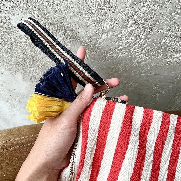 Kézzel készített vászon tassel klutch csíkos díszítéssel, cipzáros záródás, vízszintes négyzet alakú forma, belső cipzáros zseb, poliészter bélés