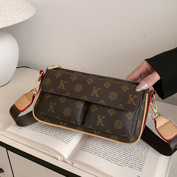 PU anyagú vállra akasztható táska, horizontális négyszögletes forma, cipzáras záródás, belső: cipzárral záródó rejtett zseb és telefontartó zseb, poliészter bélés