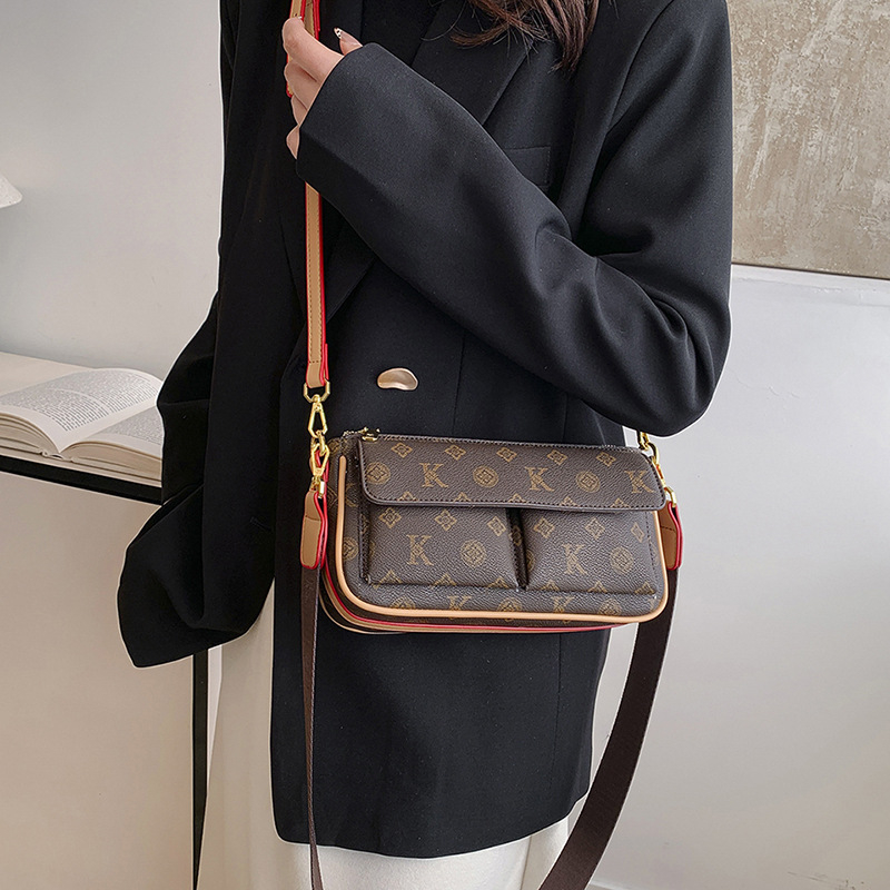 PU anyagú vállra akasztható táska, horizontális négyszögletes forma, cipzáras záródás, belső: cipzárral záródó rejtett zseb és telefontartó zseb, poliészter bélés