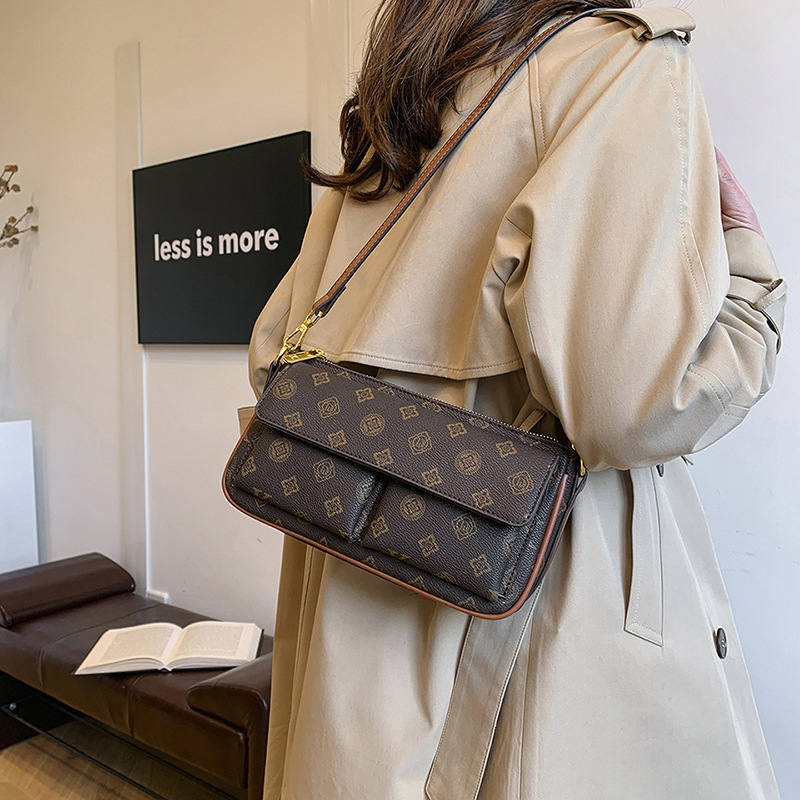 PU anyagú vállra akasztható táska, horizontális négyszögletes forma, cipzáras záródás, belső: cipzárral záródó rejtett zseb és telefontartó zseb, poliészter bélés