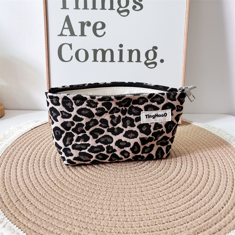 Leopárdmintás kozmetikai táska – pamut anyag, horizontális négyzet alakú forma, cipzáras nyitás, belső cipzáros zseb, belső bélés poliészter-pamut, utazáshoz ideális