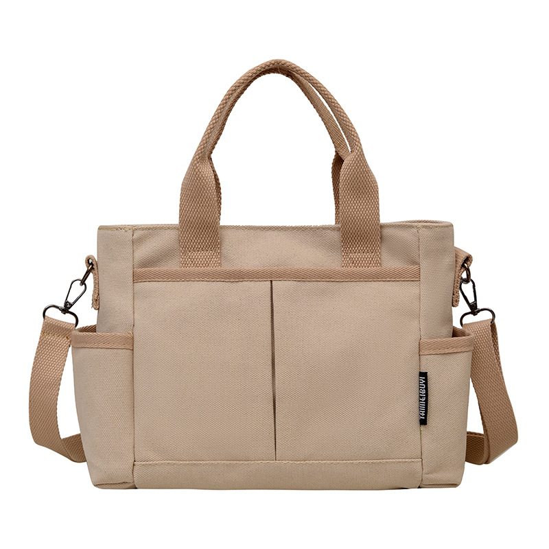 Geantă tote din pânză, cu stil urban minimalist, formă orizontală pătrată, închidere cu fermoar, buzunar pentru ID, trei curele de umăr și căptușeală poliester-bumbac.