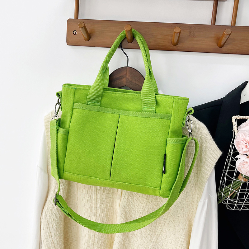 Geantă tote din pânză, cu stil urban minimalist, formă orizontală pătrată, închidere cu fermoar, buzunar pentru ID, trei curele de umăr și căptușeală poliester-bumbac.