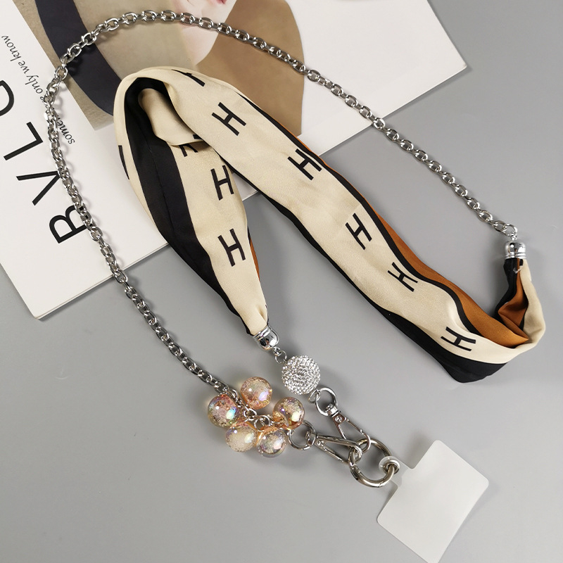 Telefona vāciņš ar noņemamu tekstila siksniņu crossbody, režģa metāla ķēdi un teksta piekariņu - roku darbs