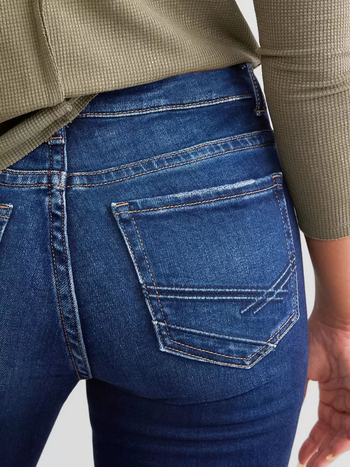 Moteriški džinsai iš džinsinio audinio, vidutinio juosmens, elastiniai, su įtrūkimais, šiek tiek platėjantys keliai, medvilnės-poliesterio mišinys (50–70% medvilnės, <30% poliesterio)