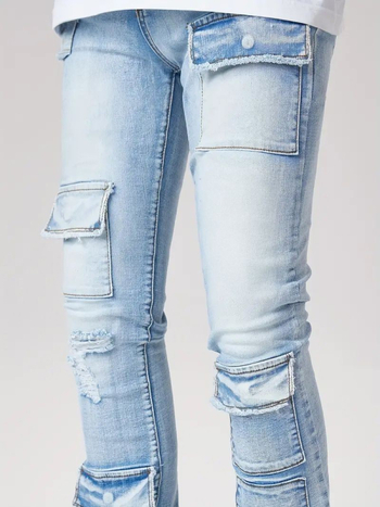 Džinsai gatvės stiliuje su keliomis kišenėmis, šiek tiek platėjantis kelnių galas, vidutinio aukščio juosmuo, užtrauktukas