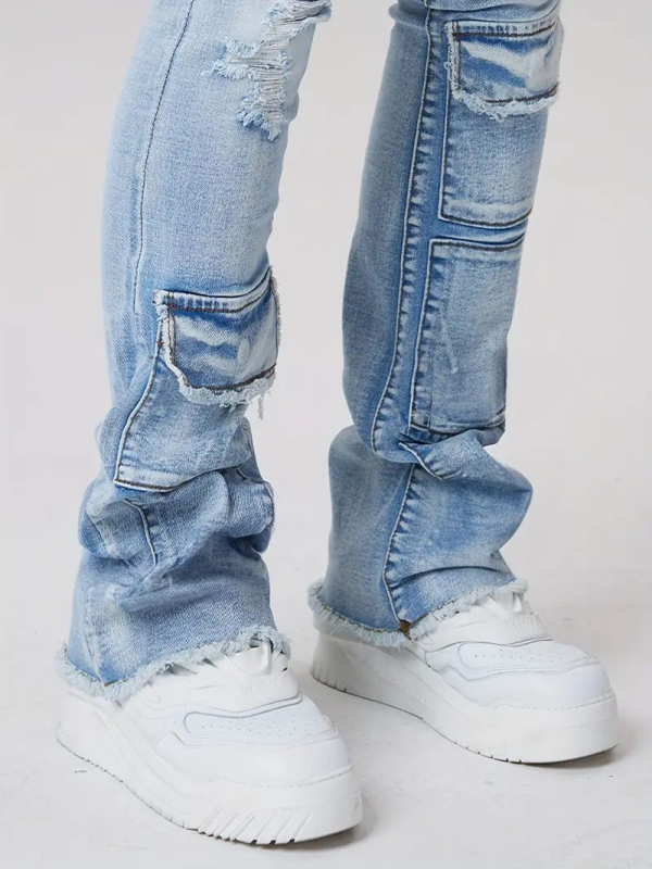 Džinsai gatvės stiliuje su keliomis kišenėmis, šiek tiek platėjantis kelnių galas, vidutinio aukščio juosmuo, užtrauktukas