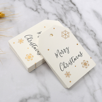 Kalėdinė dovanos etiketė su bronziniu įspaudu ant popierinės kortelės, su užrašu Merry Christmas ir snaigės dizainu