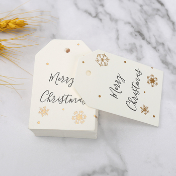 Kalėdinė dovanos etiketė su bronziniu įspaudu ant popierinės kortelės, su užrašu Merry Christmas ir snaigės dizainu