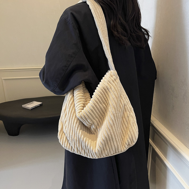 Corduroy pečių krepšys – viena dirželė, horizontalaus kvadrato formos, užtrauktukas atidarymas, vidinė kišenė su užtrauktuku, poliesterio pamušalas