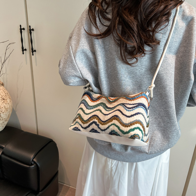 Etno-stílusú crossbody táska, csíkos mintával, horizontálisan négyzetes forma, cipzáras nyitás, nylon bélés, egy vállpánt, mindennapi használatra