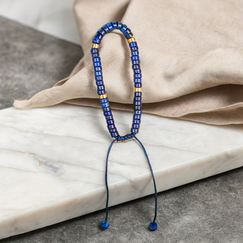 Természetes lazisz lazuli gyöngyökkel készült karkötő, görgő formájú gyöngyökkel és spacerrel, szőtt zsinórral, kézzel készített.