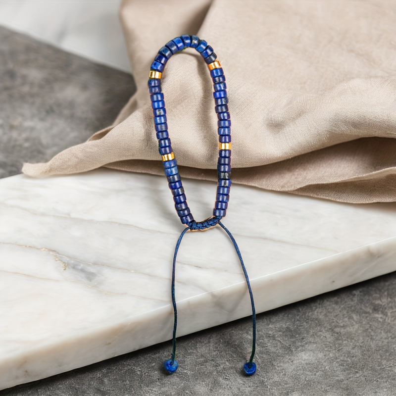 Természetes lazisz lazuli gyöngyökkel készült karkötő, görgő formájú gyöngyökkel és spacerrel, szőtt zsinórral, kézzel készített.