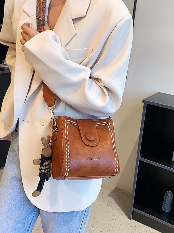 Sieviešu bucket soma ar plecu siksnu - vertikāla kvadrātforma, PU āda, kapuces aizvērums, iekšējais telefona kabatiņa, pavasaris 2024