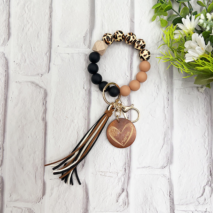 Szilikon gyöngyös karkötő kulcstartóval, leopárd mintás fa gyöngyökkel, körkörös fa medállal és bojt