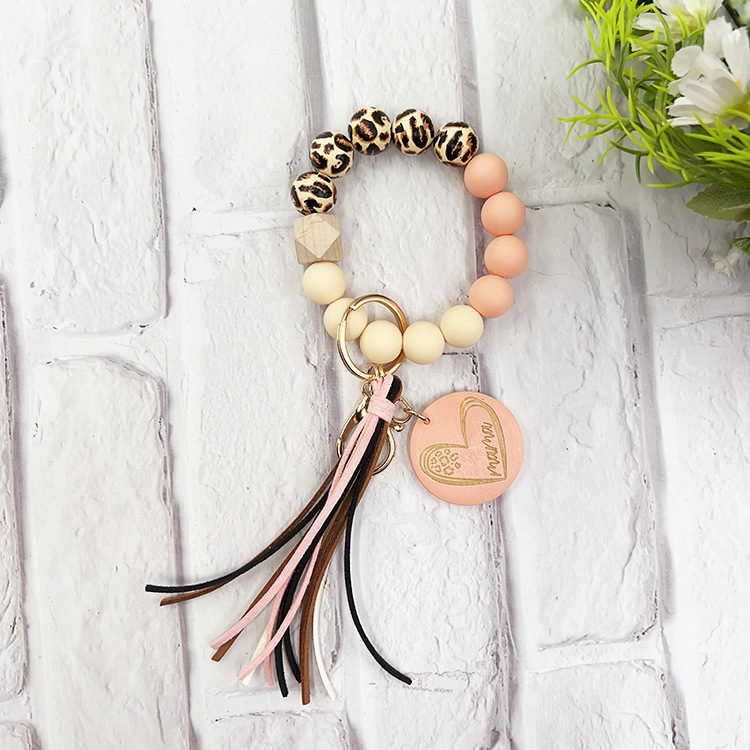 Szilikon gyöngyös karkötő kulcstartóval, leopárd mintás fa gyöngyökkel, körkörös fa medállal és bojt
