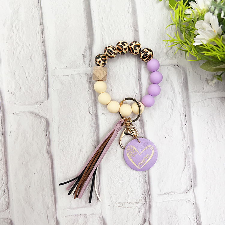 Szilikon gyöngyös karkötő kulcstartóval, leopárd mintás fa gyöngyökkel, körkörös fa medállal és bojt