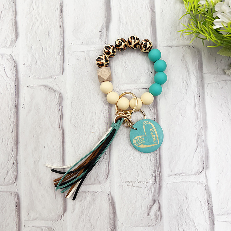 Szilikon gyöngyös karkötő kulcstartóval, leopárd mintás fa gyöngyökkel, körkörös fa medállal és bojt