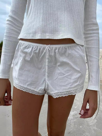 Moteriški nėrinių šortai su elastine žemąja juosmeniu, liekninanti siluetą, plačios kojos, poliesterio–medvilnės mišinys (90–95% poliesterio, <30% medvilnės).