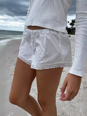 Moteriški nėrinių šortai su elastine žemąja juosmeniu, liekninanti siluetą, plačios kojos, poliesterio–medvilnės mišinys (90–95% poliesterio, <30% medvilnės).