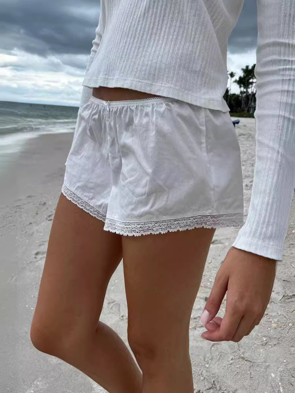 Moteriški nėrinių šortai su elastine žemąja juosmeniu, liekninanti siluetą, plačios kojos, poliesterio–medvilnės mišinys (90–95% poliesterio, <30% medvilnės).