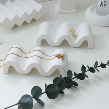 Gipses fons produktu fotografēšanai – minimālistisks viļņots nestandarta kāpņu dizains