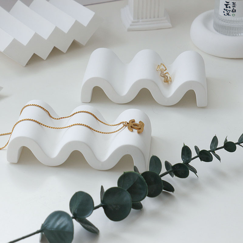 Gipses fons produktu fotografēšanai – minimālistisks viļņots nestandarta kāpņu dizains