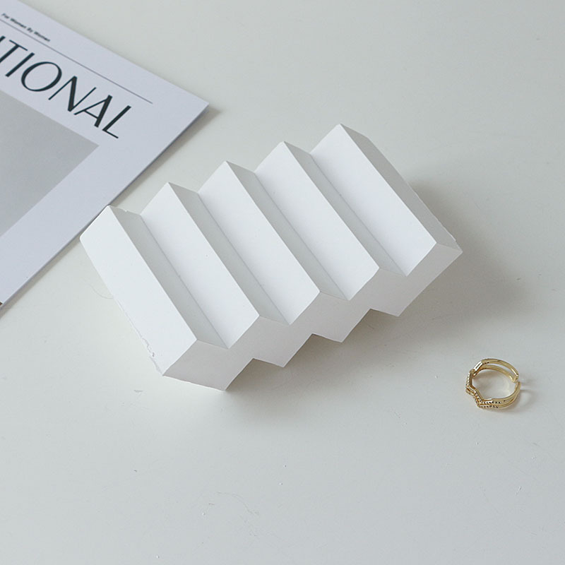 Gipses fons produktu fotografēšanai – minimālistisks viļņots nestandarta kāpņu dizains