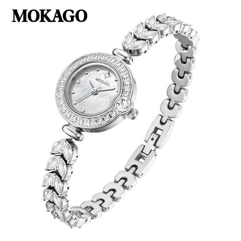 Naise kvartsikell teemantidega kaunistusega ja vasest kettaga kalasaba kujul, ümmargune kellakera (kvartsliikumine; teemantidega kaunistus; vasest kett kalasaba kujul; veekindlus 30 m; ümmargune kellakera)