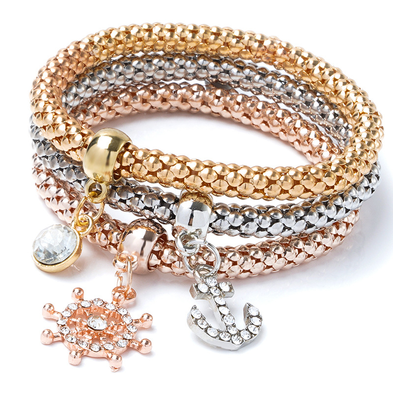 Ženska narukvica — trobojna legura, elastična, lanac u stilu popcorn, privjesak srce sa kamenčićima