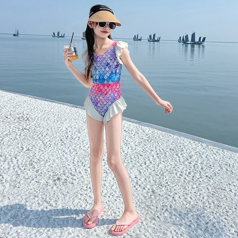 Meitenēm – viengabala peldkostīms ar sirēnas motīvu, salds raksts, poliesteris 30%, pludmalē