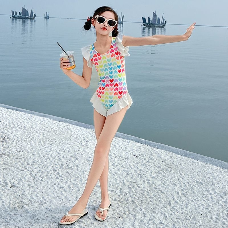 Meitenēm – viengabala peldkostīms ar sirēnas motīvu, salds raksts, poliesteris 30%, pludmalē