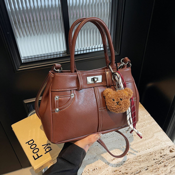 Rokassoma Kelly stilā, PU materiāls, horizontāla kvadrāta forma, aizvēršana ar latch, iekšējā rāvējslēdzēja kabata, poliestera oderējums