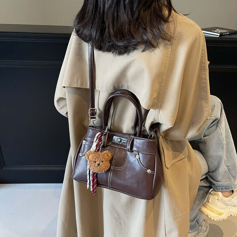 Rokassoma Kelly stilā, PU materiāls, horizontāla kvadrāta forma, aizvēršana ar latch, iekšējā rāvējslēdzēja kabata, poliestera oderējums