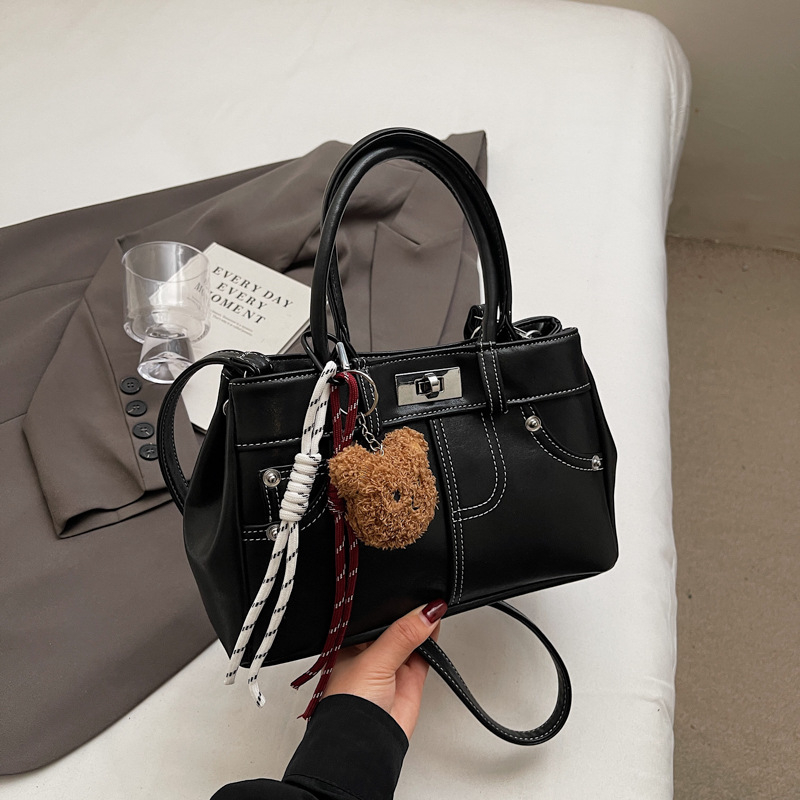 Rokassoma Kelly stilā, PU materiāls, horizontāla kvadrāta forma, aizvēršana ar latch, iekšējā rāvējslēdzēja kabata, poliestera oderējums