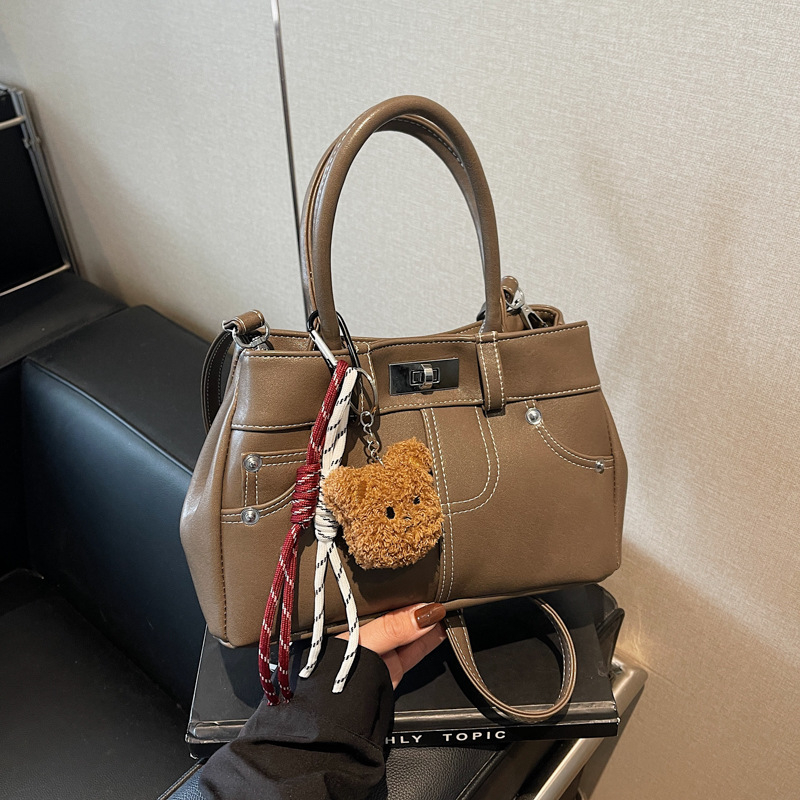 Rokassoma Kelly stilā, PU materiāls, horizontāla kvadrāta forma, aizvēršana ar latch, iekšējā rāvējslēdzēja kabata, poliestera oderējums