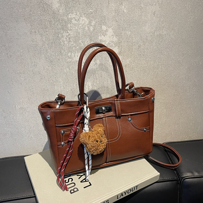 Rokassoma Kelly stilā, PU materiāls, horizontāla kvadrāta forma, aizvēršana ar latch, iekšējā rāvējslēdzēja kabata, poliestera oderējums