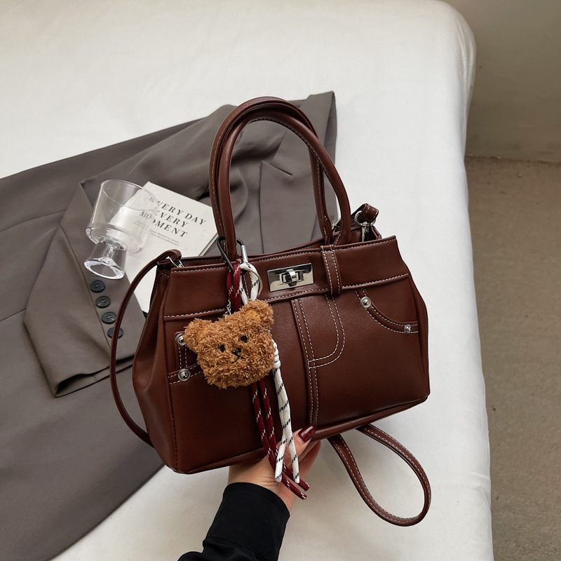 Rokassoma Kelly stilā, PU materiāls, horizontāla kvadrāta forma, aizvēršana ar latch, iekšējā rāvējslēdzēja kabata, poliestera oderējums