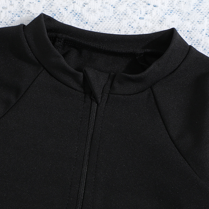 Meitenēm viengabala peldkostīms ar garām piedurknēm un rāvējslēdzēju, adīta auduma materiāls; sastāvs 95% poliesters, 5% spandeks; oderējums poliesters.