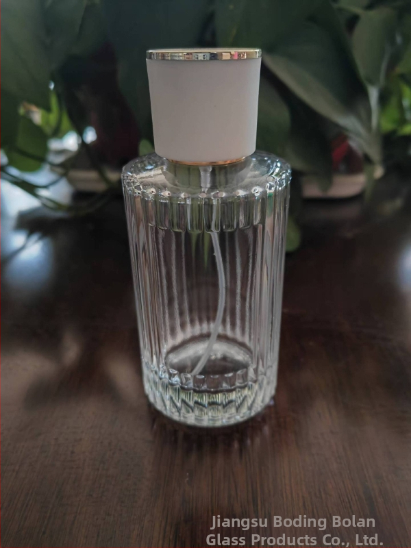 Стъклена бутилка за парфюм със винтово гърло, кръгло прозрачно тяло, дебело вертикално ивично стъкло, голям страничен спрей, тежък капак