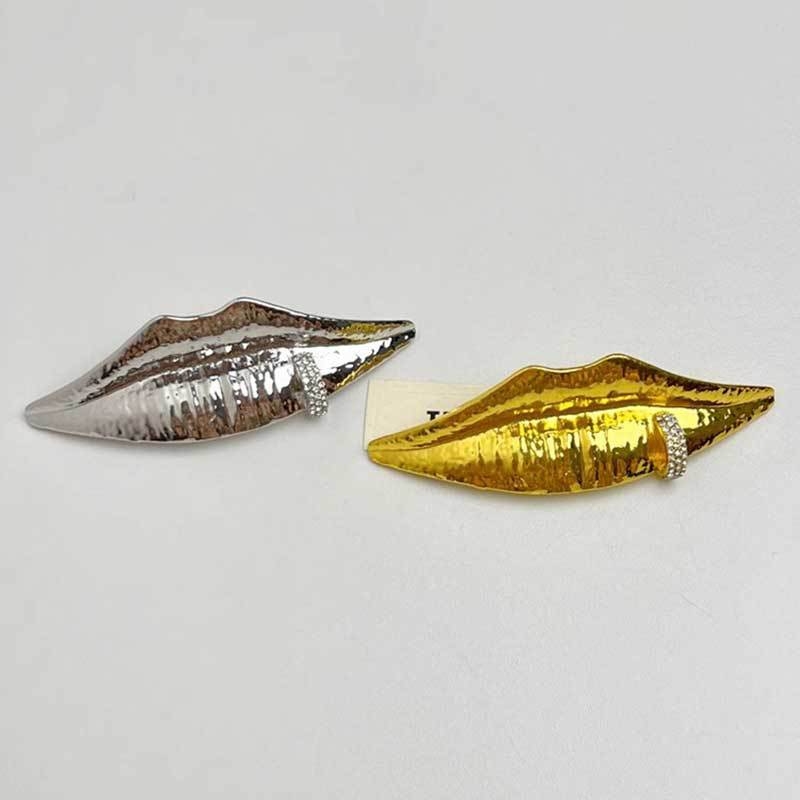 Segė su veido ir lūpų motyvu – metalas, elektroplatavimas, atminimui ir dekoratyvinis, pavasaris 2025