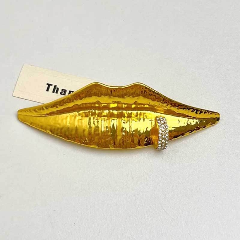 Broš s motivom lica i usana – metal, elektroplatiranje, memorijalna i dekorativna, proljeće 2025