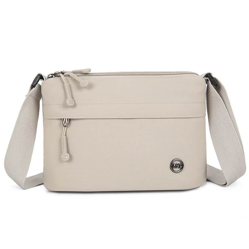 Nailona crossbody soma, pilsētas minimālisma stils, mazs kvadrāta formāts, rāvējslēdzēja atvērums, poliesteru odere, iekšējie kabati ar rāvējslēdzēju