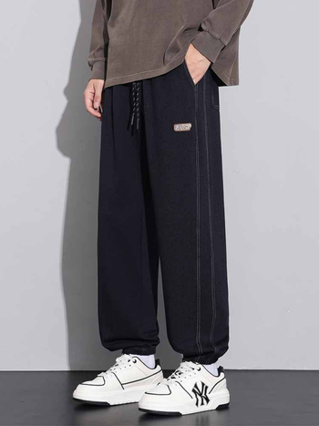 Sportske dnevne hlače, ravni kroj, zatvaranje šnirnom vezicom, poliester tkanina, tekstualni uzorak.