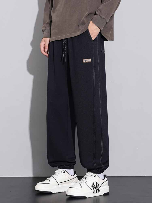 Sportske dnevne hlače, ravni kroj, zatvaranje šnirnom vezicom, poliester tkanina, tekstualni uzorak.