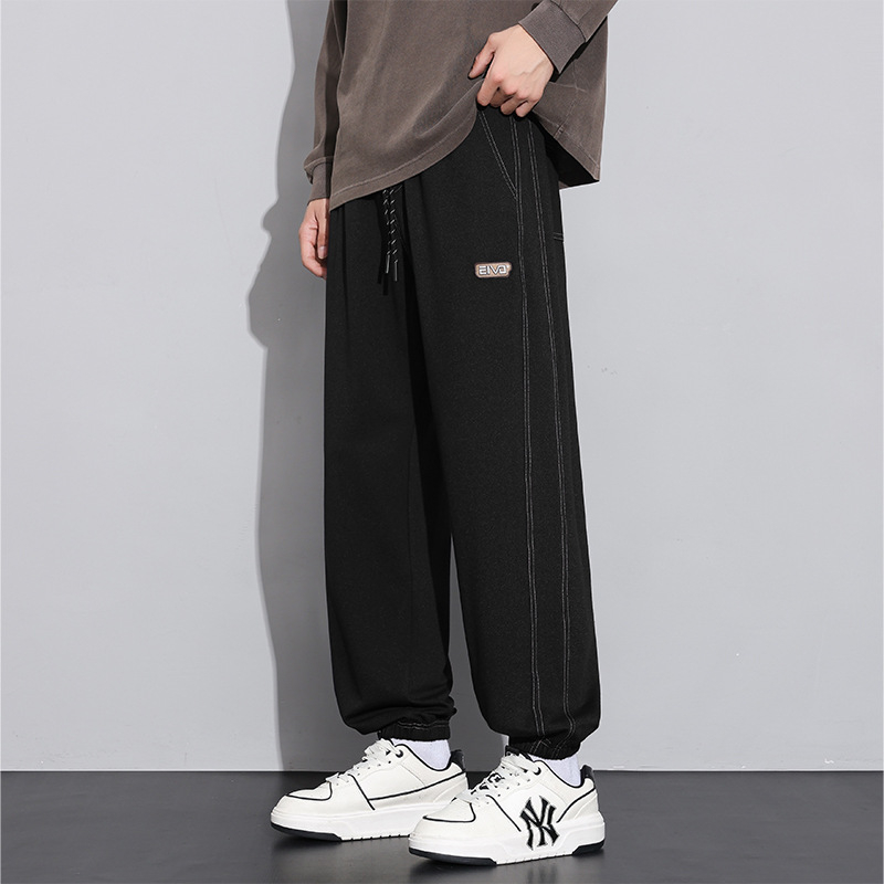 Sportske dnevne hlače, ravni kroj, zatvaranje šnirnom vezicom, poliester tkanina, tekstualni uzorak.