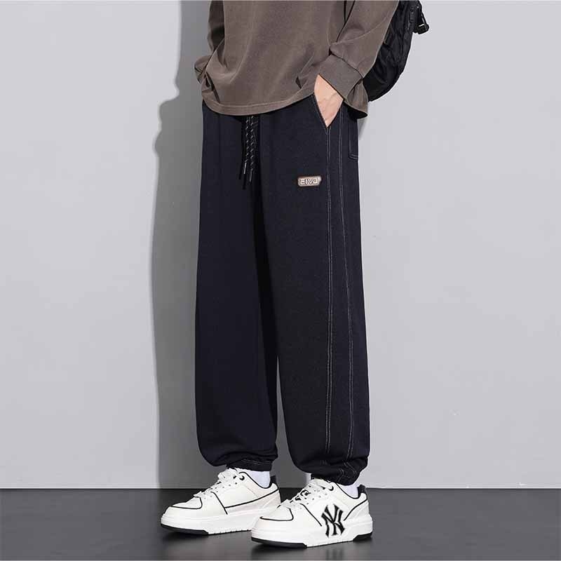 Sportske dnevne hlače, ravni kroj, zatvaranje šnirnom vezicom, poliester tkanina, tekstualni uzorak.