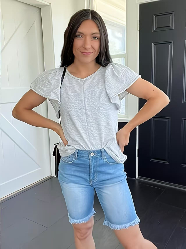 Ženske traperice srednje duljine, visokim strukom, elastične, naglašavaju siluetu, rubovi s friziranim završetkom