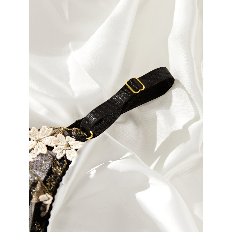 Set donjeg rublja s broderijom, grudnjak s trokutastim košaricama, tangice i jartijerica — trokutasti košarice, srednje oblikovane košarice; glavni materijal 97% poliester, 3% elastan; podstava 97% poliester, 3% elastan